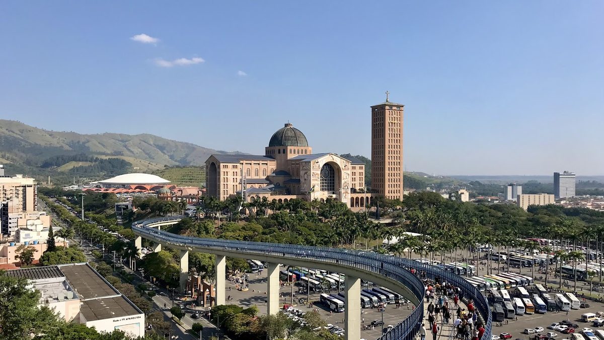 Basílica de Aparecida e a Passarela da Fé vistas do alto, com a serra ao fundo