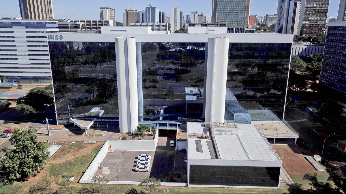 Prédio do INSS em Brasília, com fachada de vidro e duas colunas brancas, visto do alto