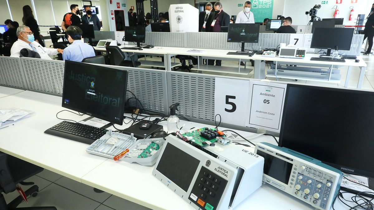 Urna eletrônica e computadores em sala de testes da Justiça Eleitoral