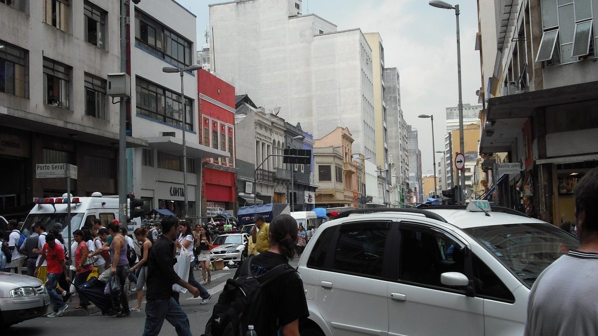 Pessoas com sacolas de compras na Rua 25 de Março, no centro de São Paulo