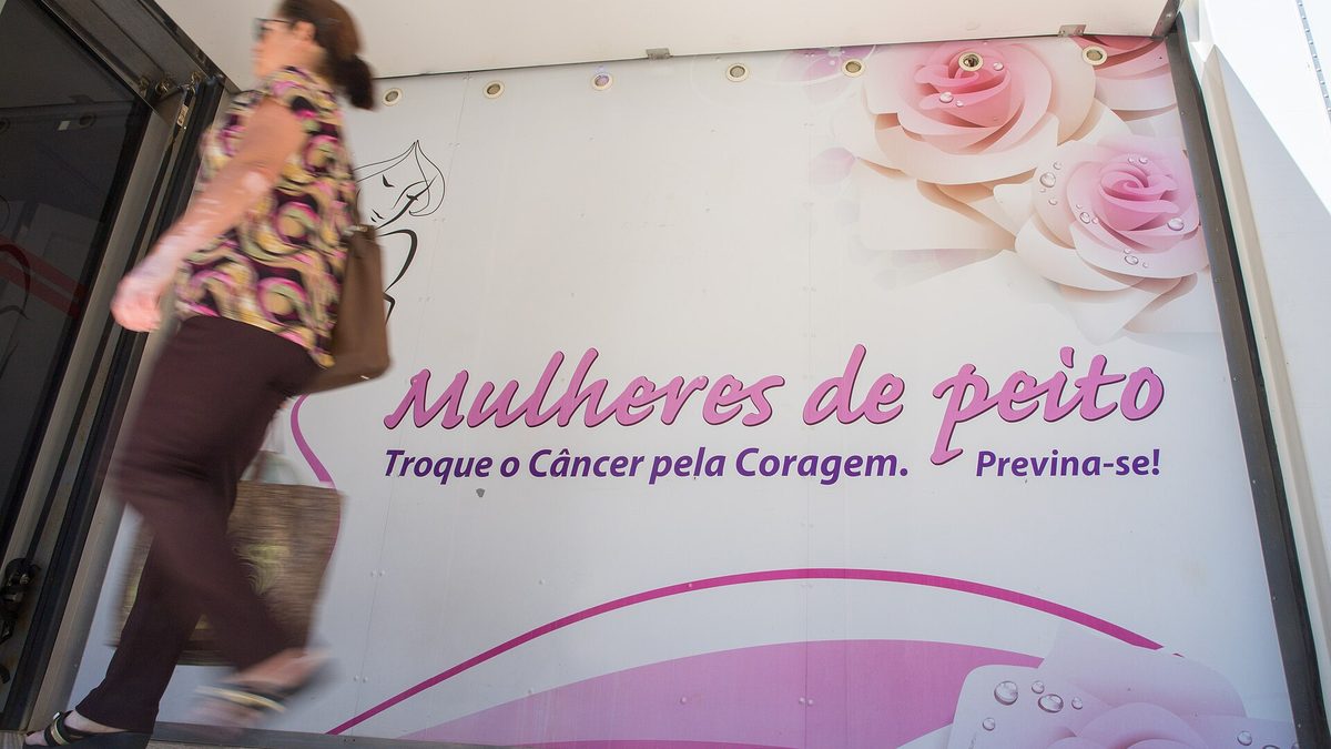 Mulher passa pela entrada de uma carreta do programa Mulheres de Peito, em Mogi das Cruzes (SP)