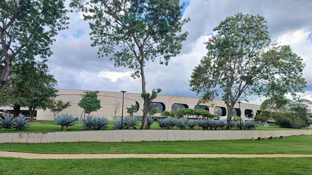 Jardim e prédio curvo de janelas arredondadas do Centro Cultural Banco do Brasil, em Brasília
