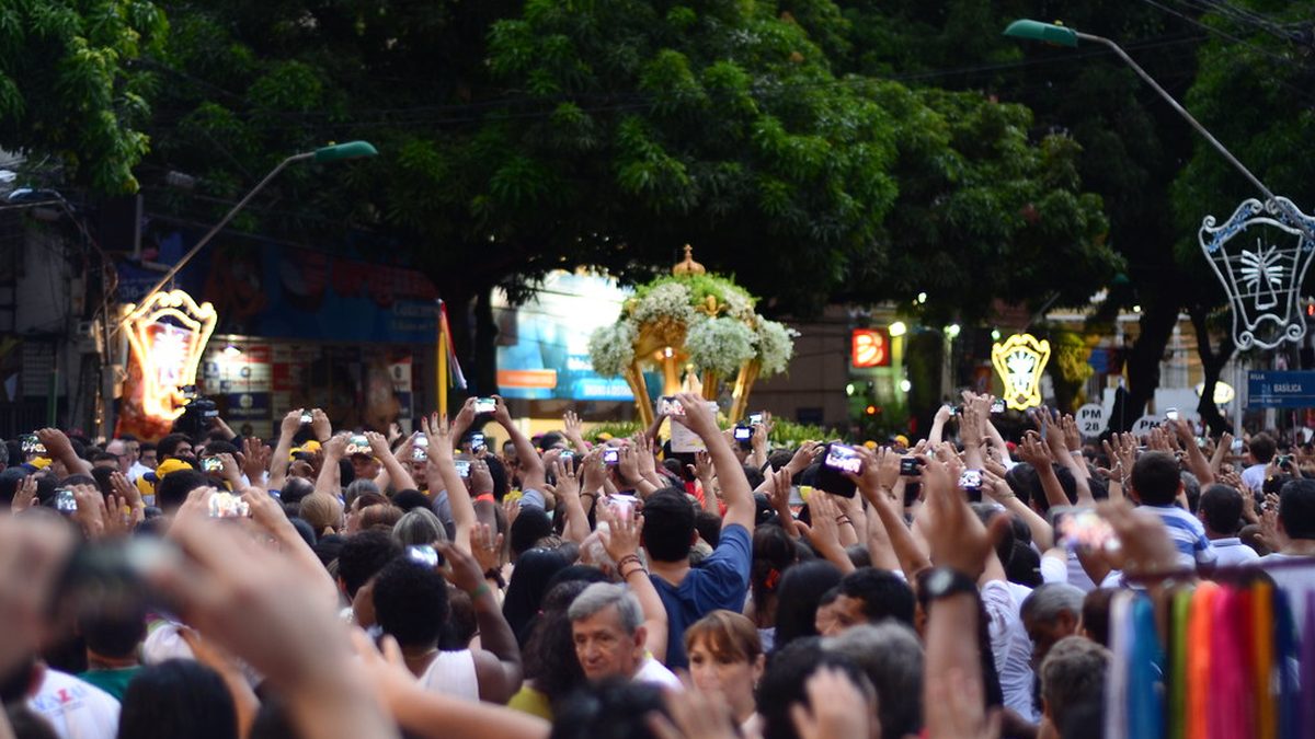Multidão de fiéis ergue as mãos à passagem da berlinda do Círio de Nazaré, em Belém