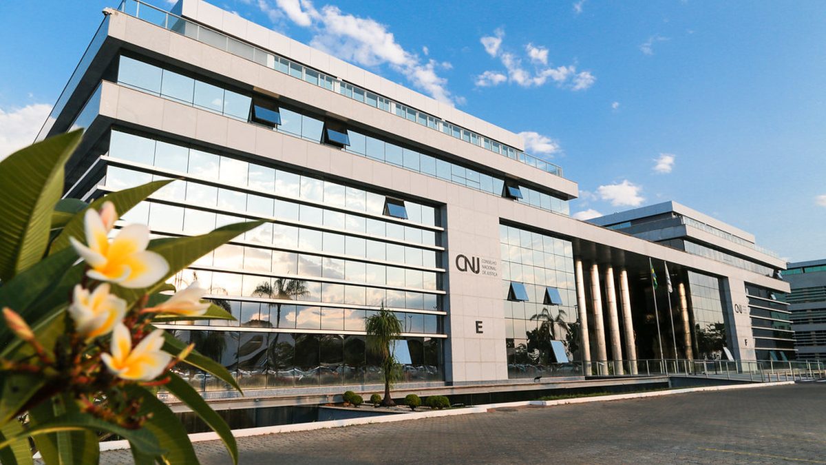 Prédio-sede do Conselho Nacional de Justiça, em Brasília, com flores em primeiro plano