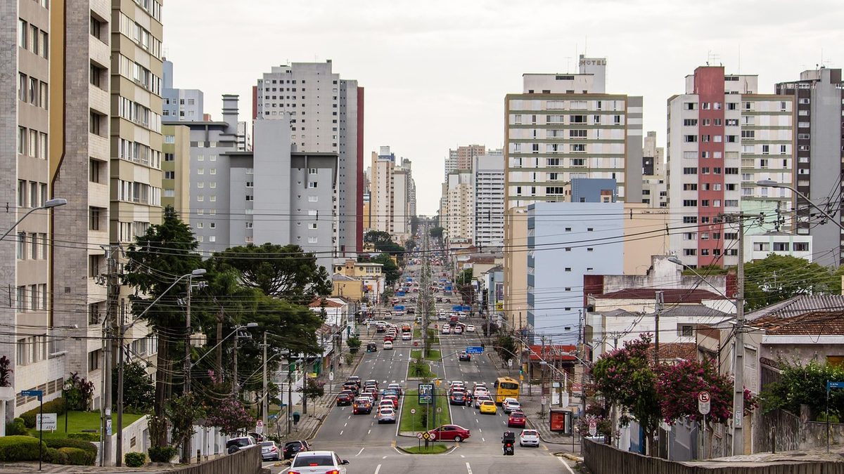 Avenida com carros e prédios altos no centro de Curitiba