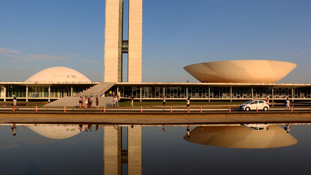 Palácio do Congresso Nacional refletido no espelho d’água ao entardecer, em Brasília