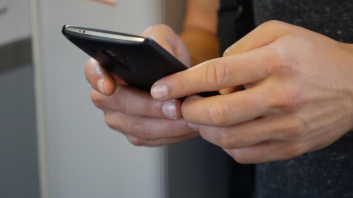 Mãos seguram um celular durante o uso de um aplicativo