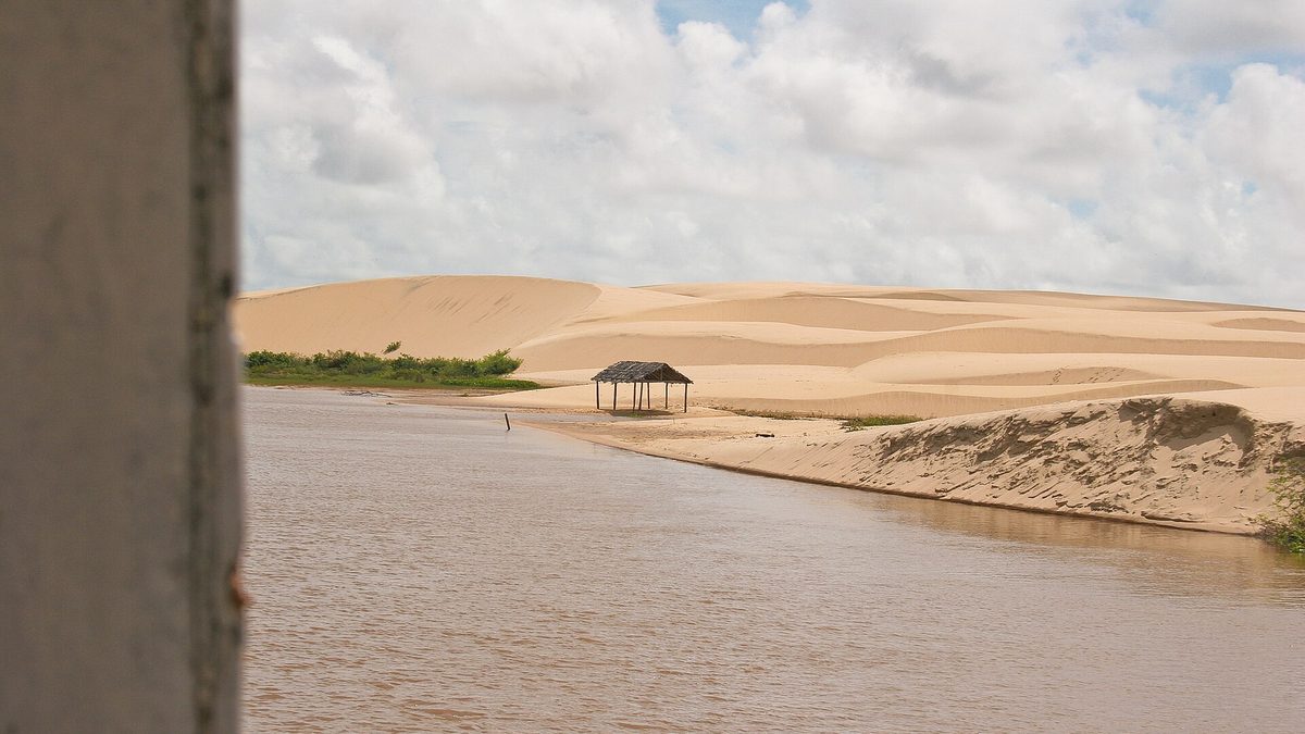 Dunas de areia clara descem até a margem do rio no Delta do Parnaíba