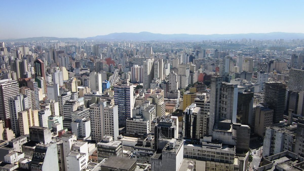 Prédios da cidade de São Paulo vistos do alto, com a serra ao fundo