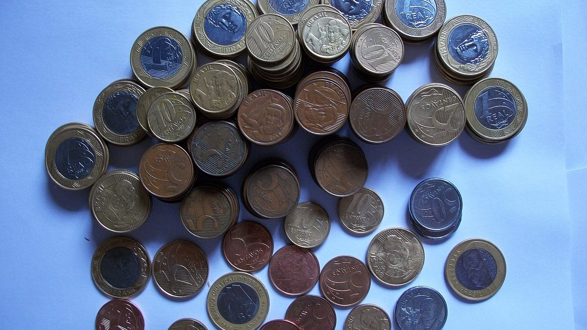Pilhas de moedas de real de vários valores sobre uma mesa clara