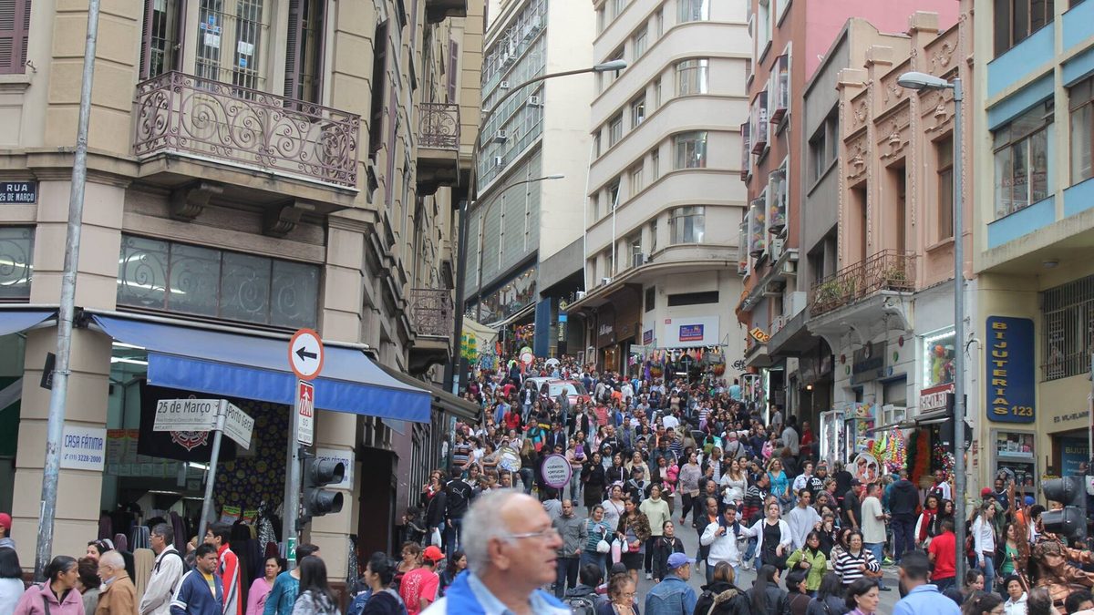 Multidão de pedestres na Rua 25 de Março, rua de comércio no centro de São Paulo