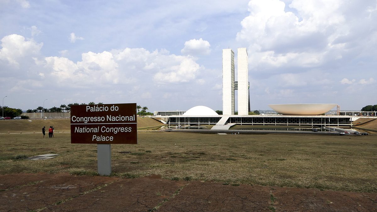 Placa do Palácio do Congresso Nacional diante das torres e das cúpulas, em Brasília
