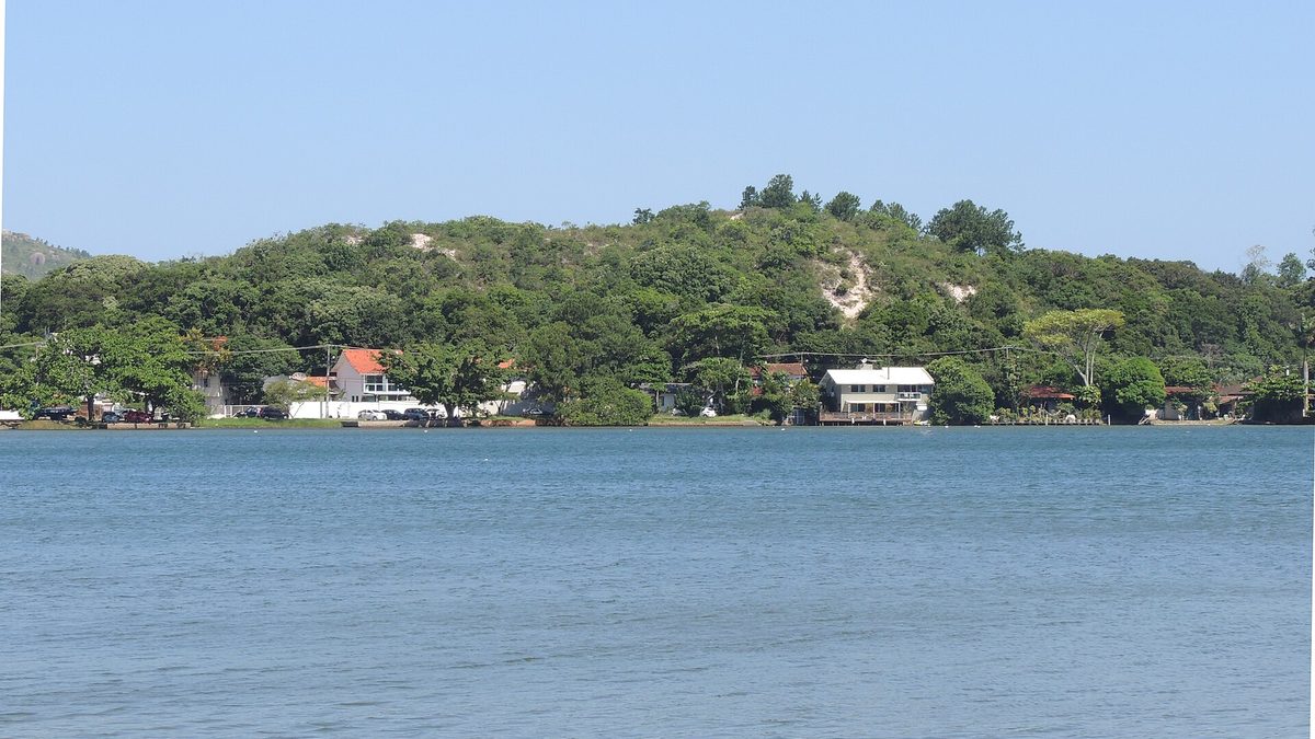 Casas e morro com mata à beira da Lagoa da Conceição, em Florianópolis