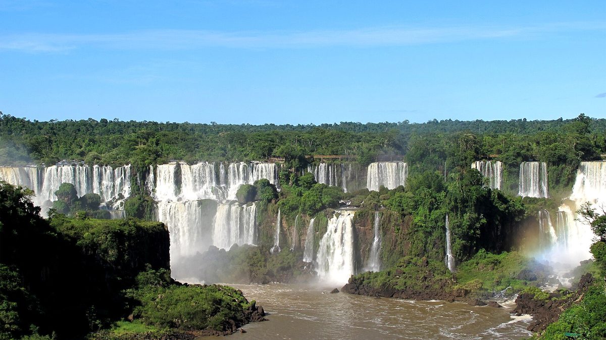 Sequência de quedas das Cataratas do Iguaçu cercadas de mata, vista de um mirante