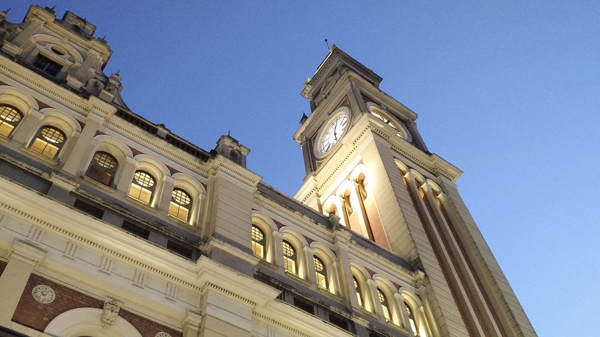 Torre do relógio da Estação da Luz iluminada ao anoitecer, em São Paulo