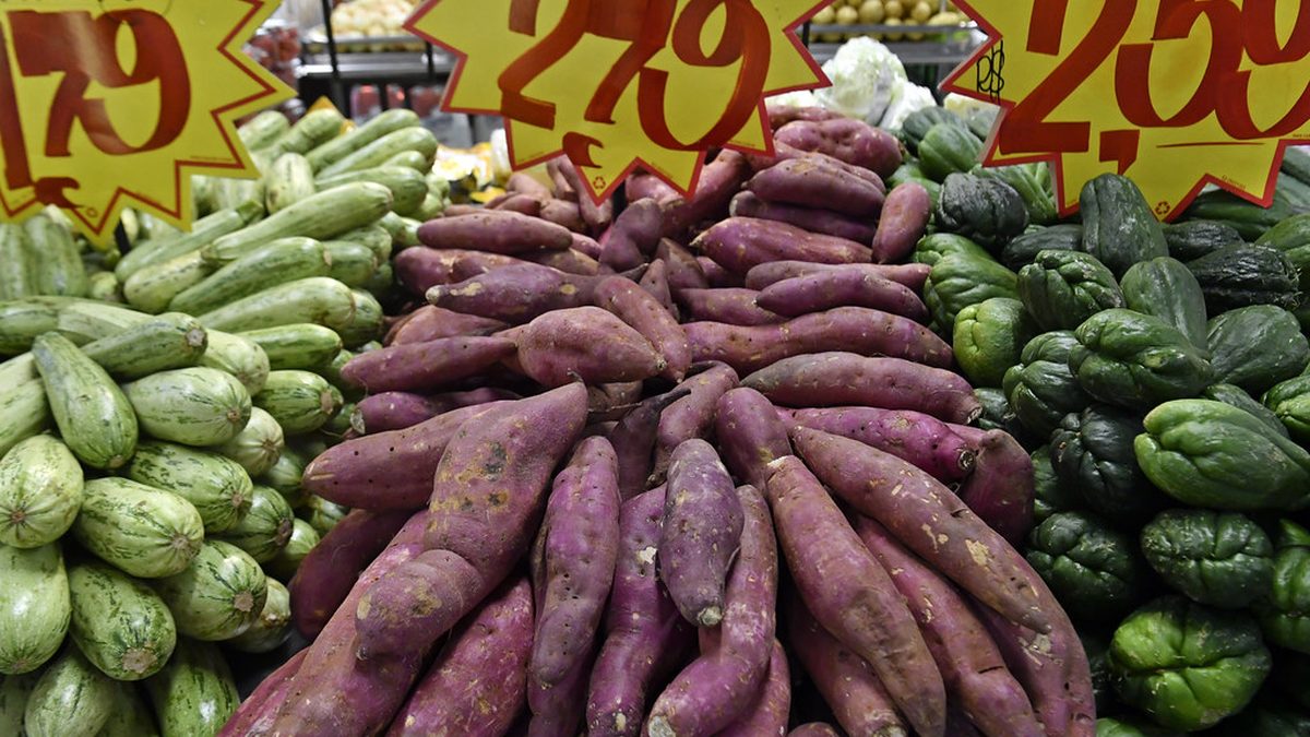 Abobrinha, batata-doce e chuchu com placas de preço em reais em banca de supermercado