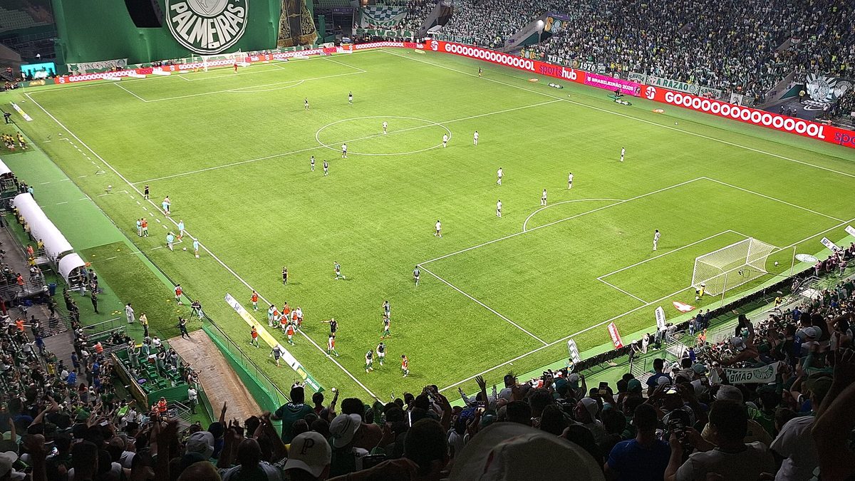 Arquibancadas cheias e gramado do estádio do Palmeiras durante jogo noturno, em São Paulo