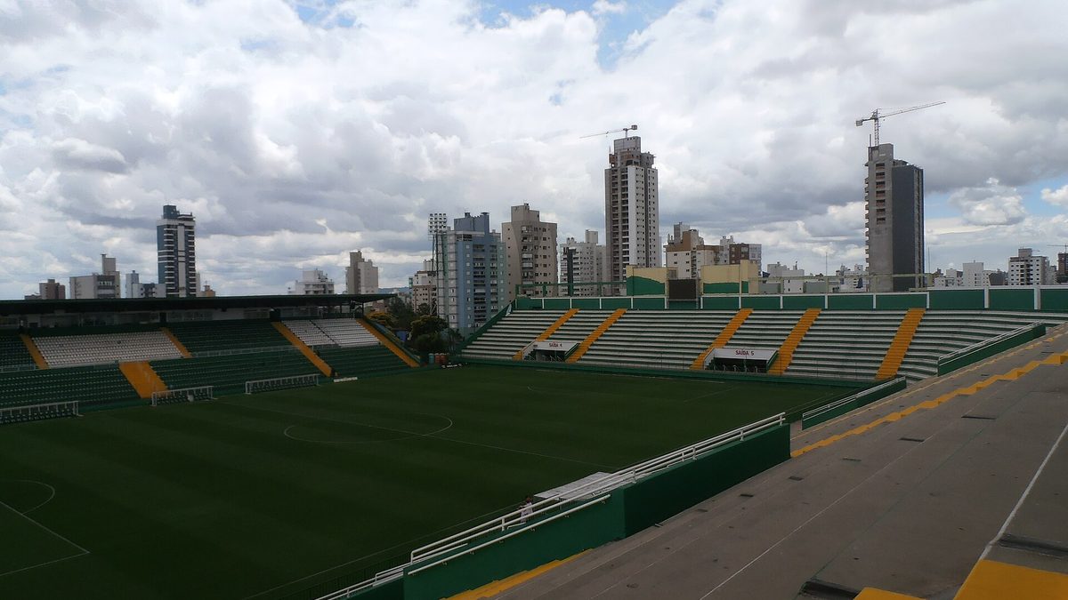 Arquibancadas e gramado da Arena Condá, com prédios de Chapecó ao fundo
