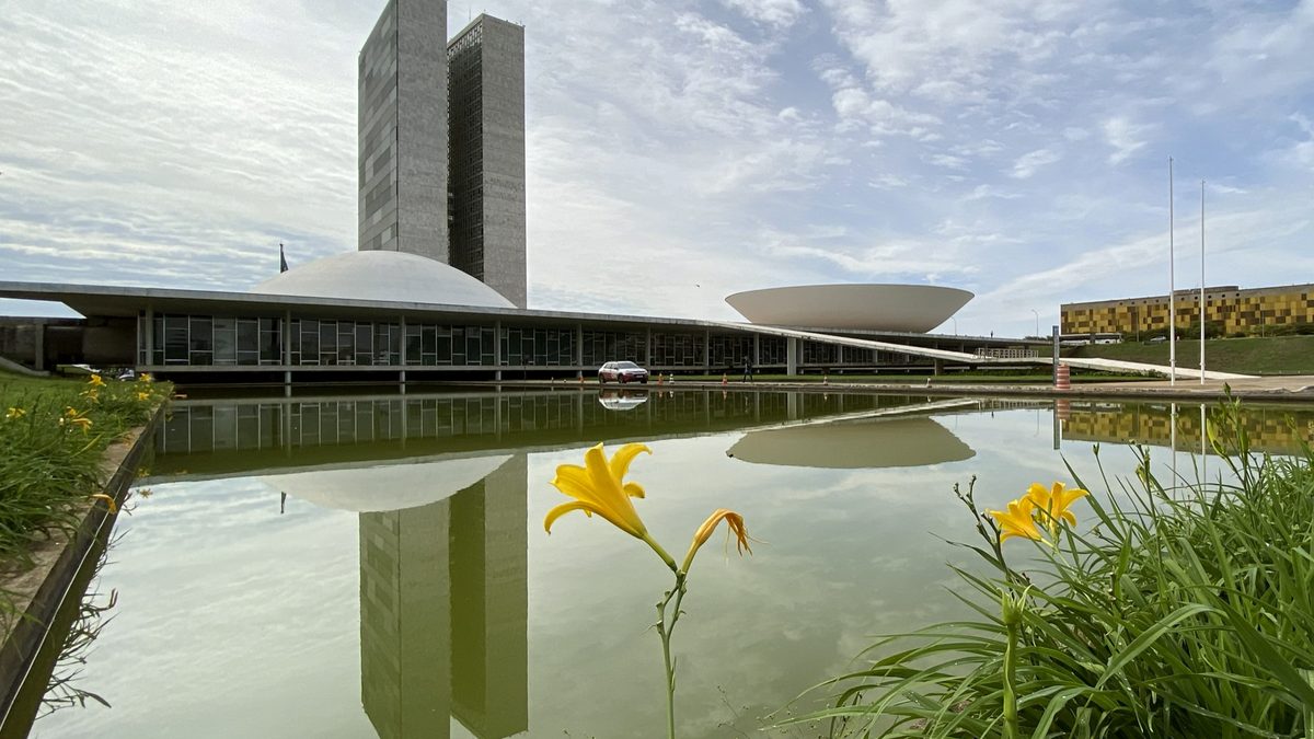 Cúpulas e torres do Congresso Nacional refletidas no espelho d’água, em Brasília