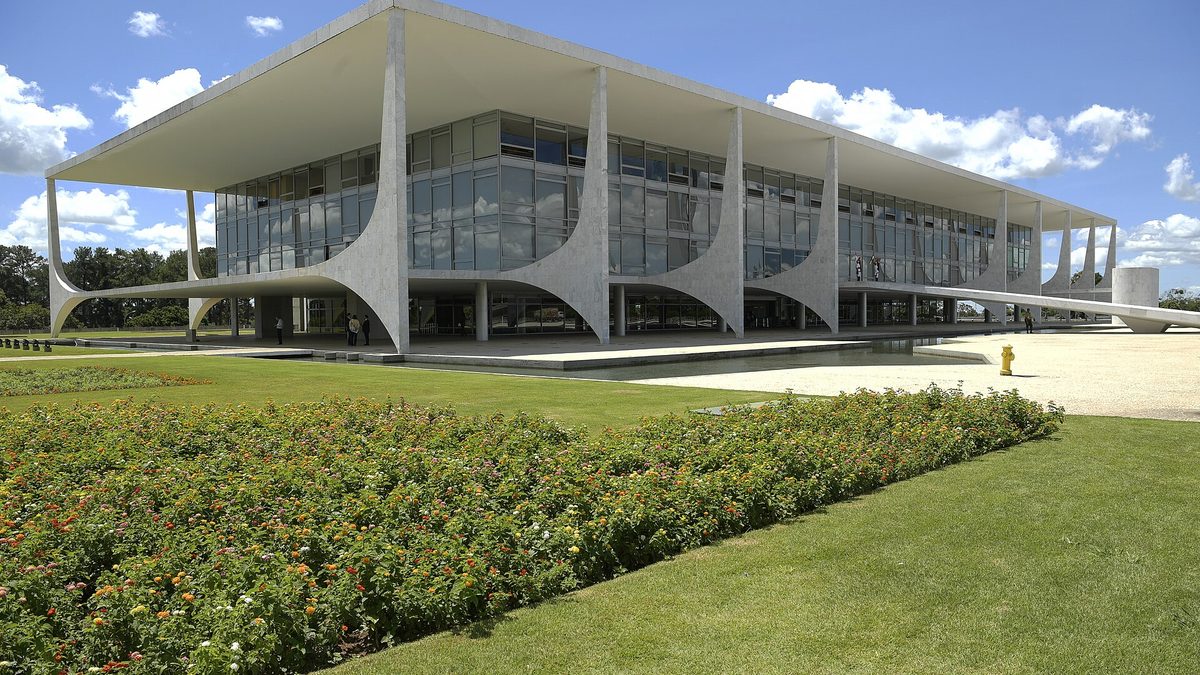Fachada do Palácio do Planalto, com colunas brancas curvas e jardim em frente, em Brasília