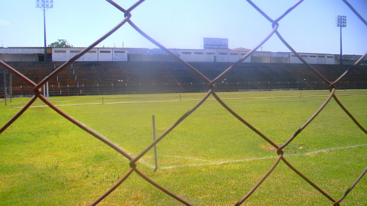 Gramado do estádio de Novo Horizonte visto através de um alambrado
