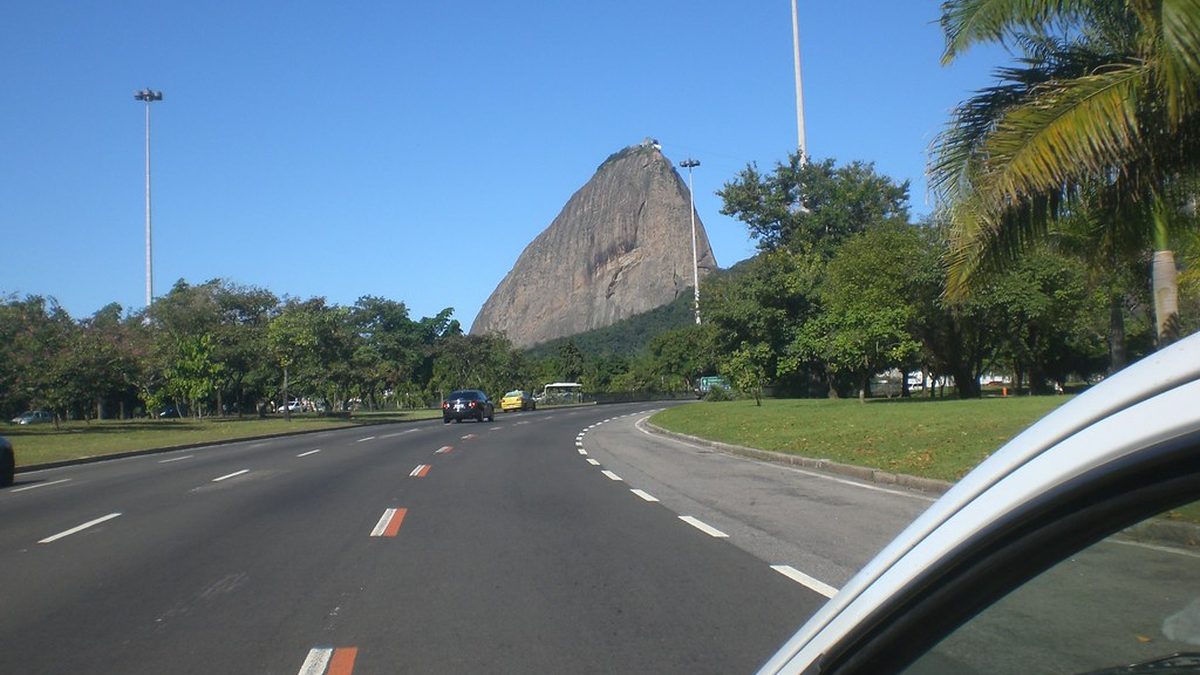 Pista do Aterro do Flamengo, no Rio de Janeiro, com o Pão de Açúcar ao fundo sob céu azul