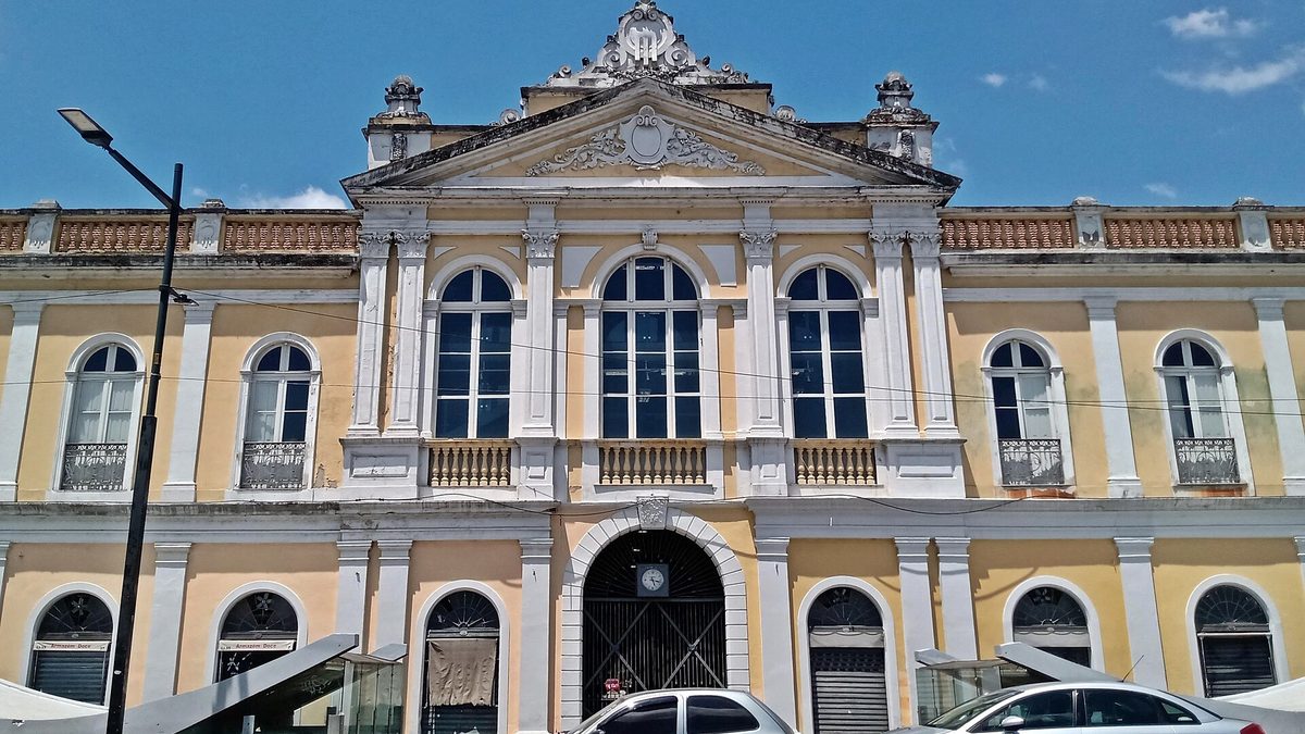 Fachada amarela do Mercado Público de Porto Alegre sob céu azul, no Centro Histórico