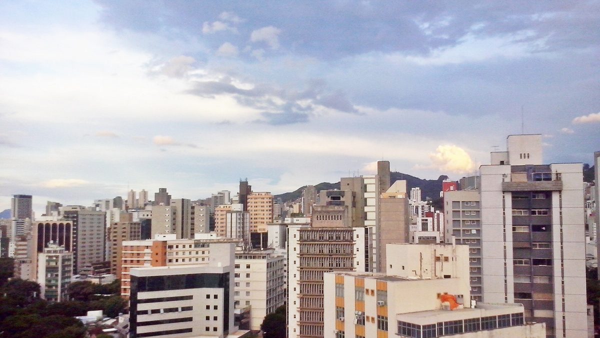 Prédios da Savassi, em Belo Horizonte, com a serra ao fundo sob céu nublado
