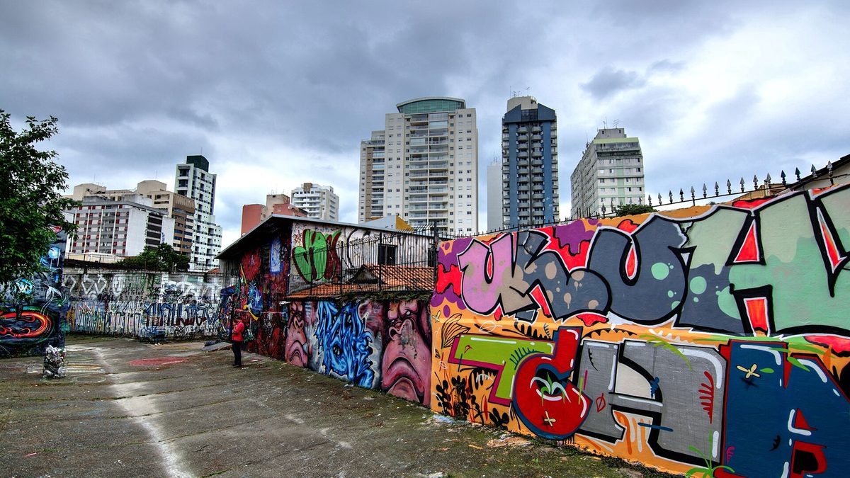 Muros grafitados e prédios residenciais ao fundo, na Vila Madalena, em São Paulo