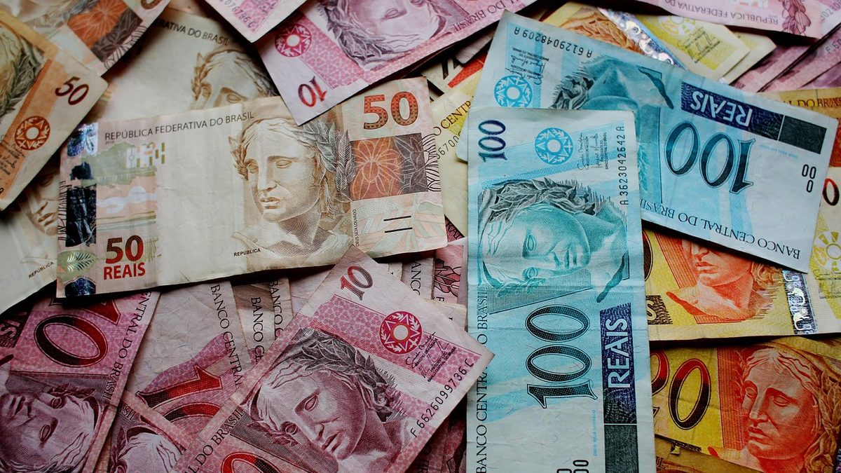 Cédulas de real de vários valores espalhadas sobre uma mesa