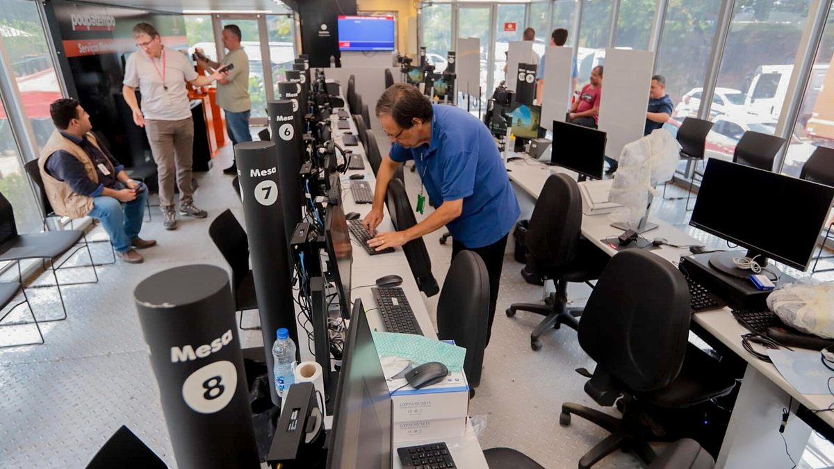 Servidores preparam computadores nos guichês do Poupatempo Móvel em São Sebastião, SP