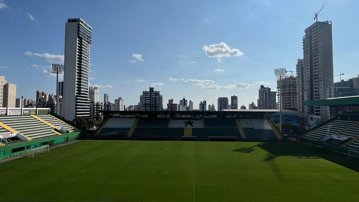 Gramado e arquibancadas da Arena Condá, com prédios de Chapecó ao fundo