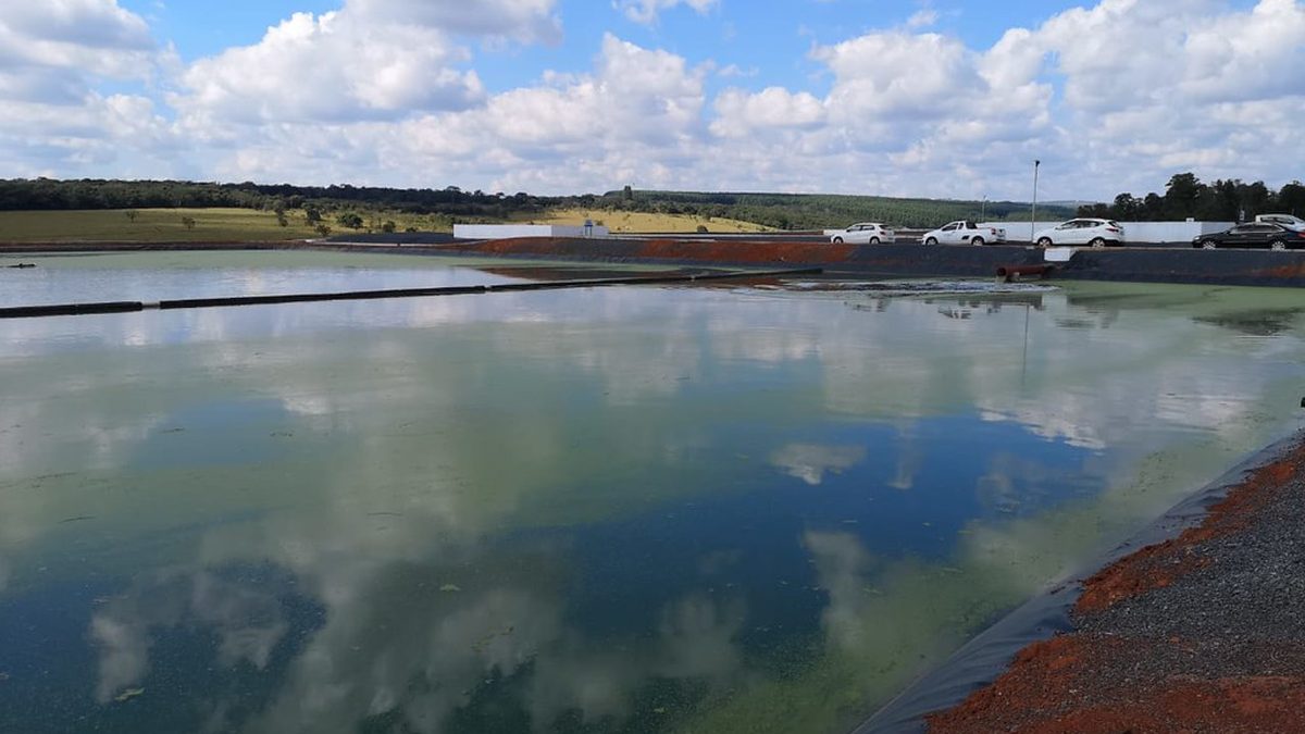 Lagoa da estação de tratamento de esgoto de Arcos, em Minas Gerais, com o céu refletido na água