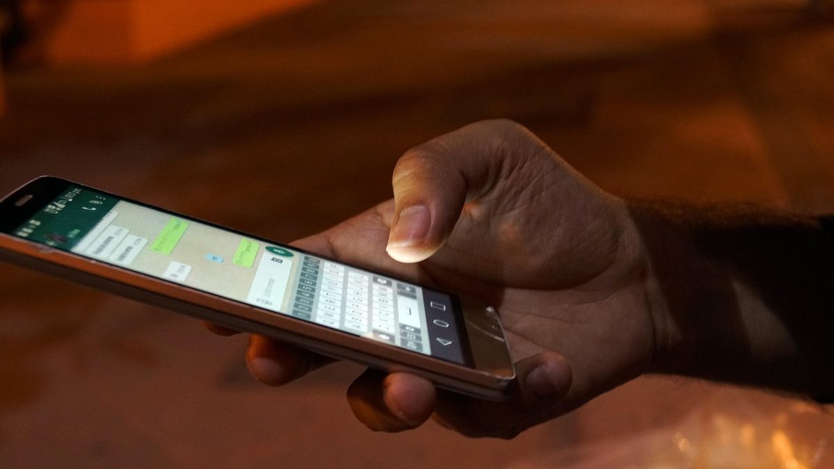 Mãos digitam uma mensagem em aplicativo de conversa no celular