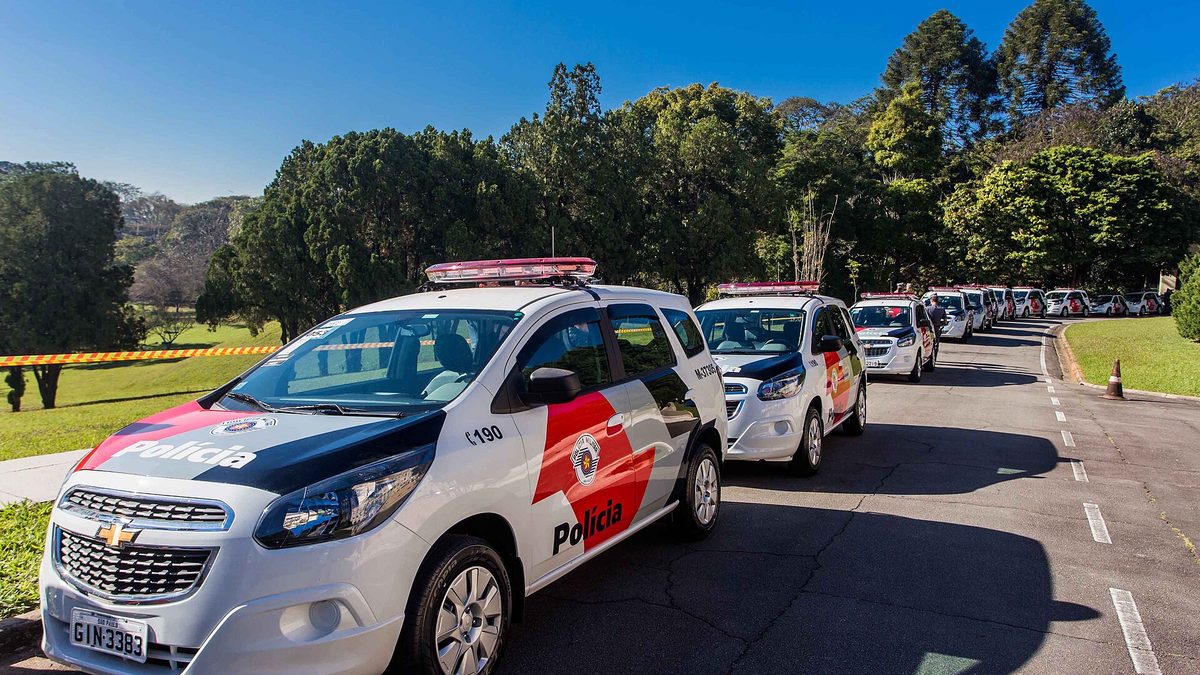 Viaturas da Polícia Militar de São Paulo enfileiradas em uma via arborizada