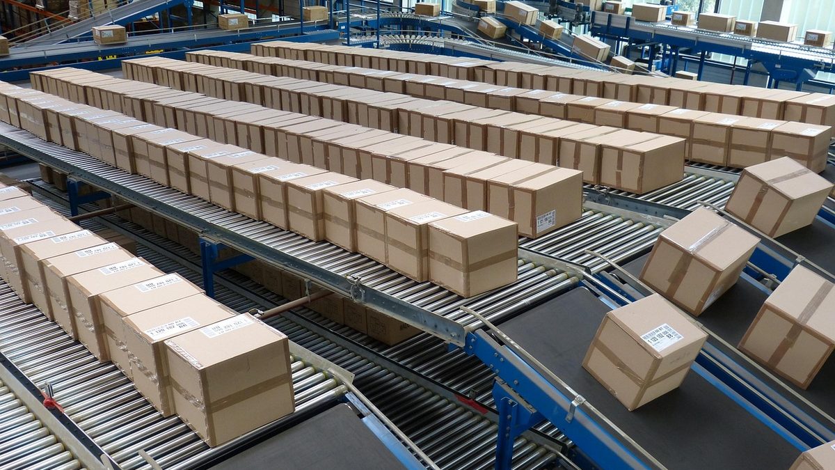 Caixas de encomendas em esteiras de triagem de um centro de distribuição