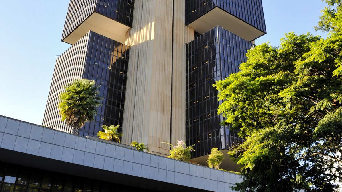 Edifício-sede do Banco Central do Brasil, em Brasília, visto de baixo entre árvores