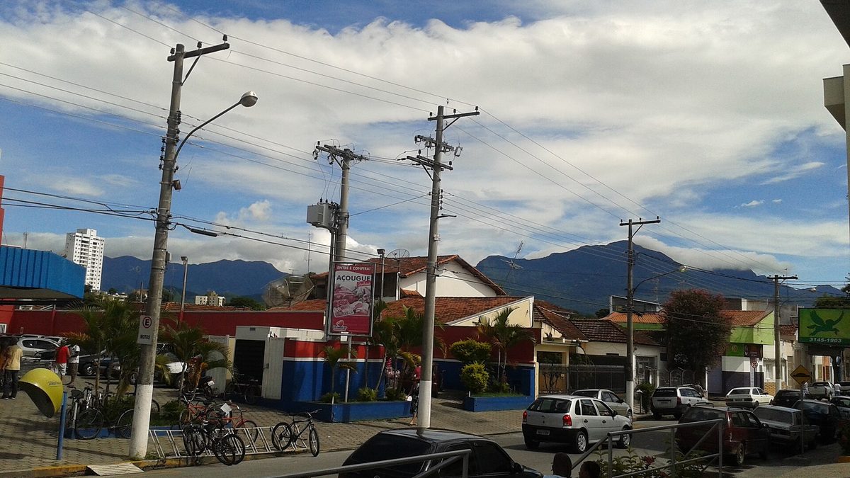Rua de Cruzeiro, no Vale do Paraíba, com postes, casas e a Serra da Mantiqueira ao fundo