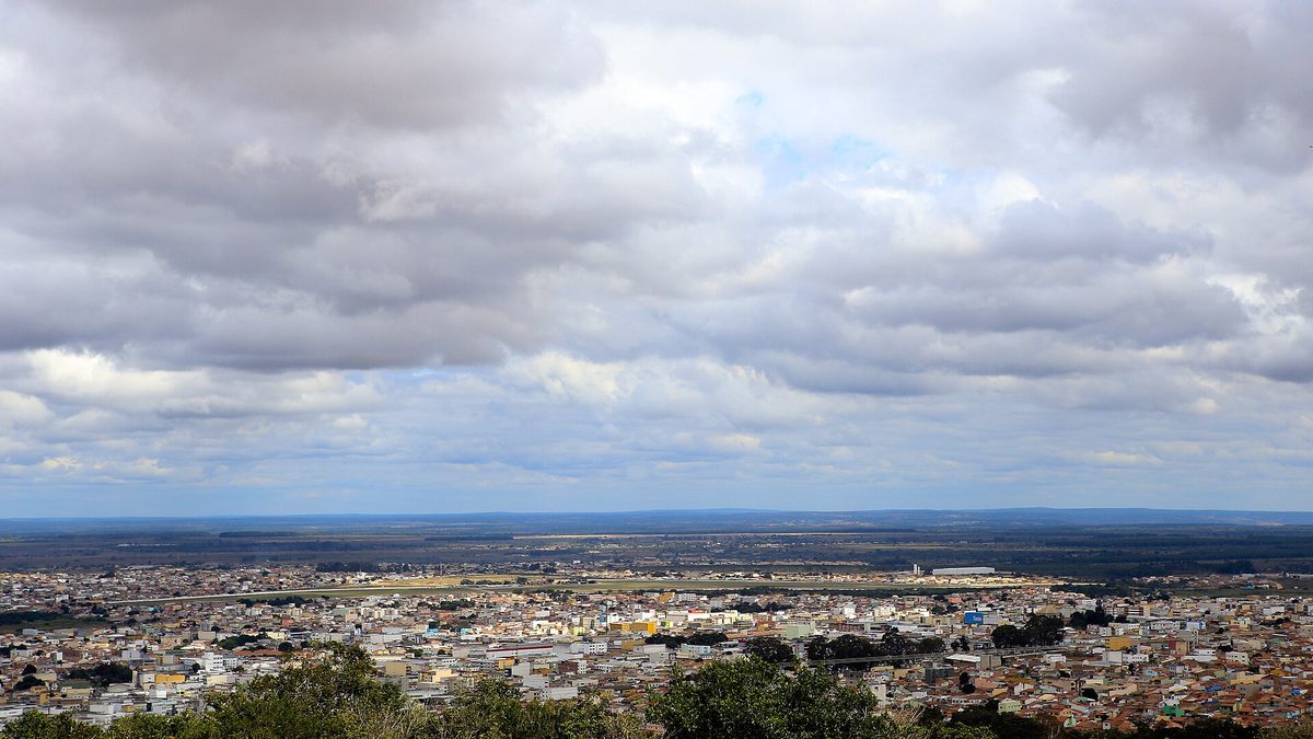 Vista panorâmica de Vitória da Conquista, na Bahia, com casas e prédios sob céu nublado