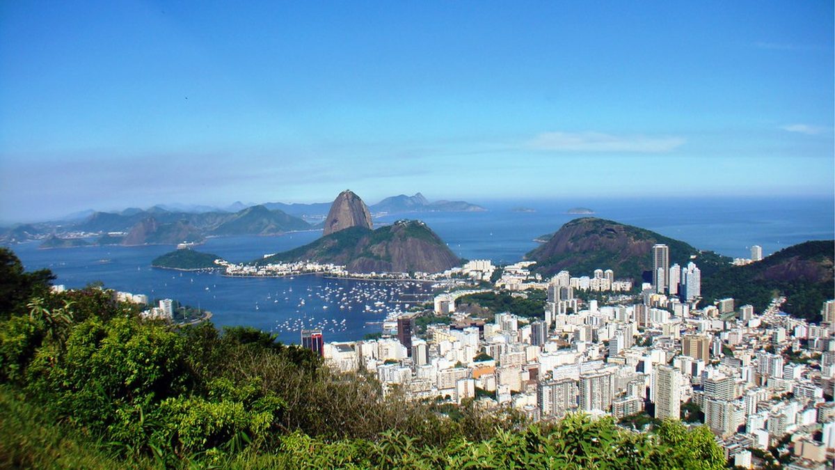 Prédios de Botafogo e enseada com o Pão de Açúcar ao fundo, vistos do alto de um morro no Rio